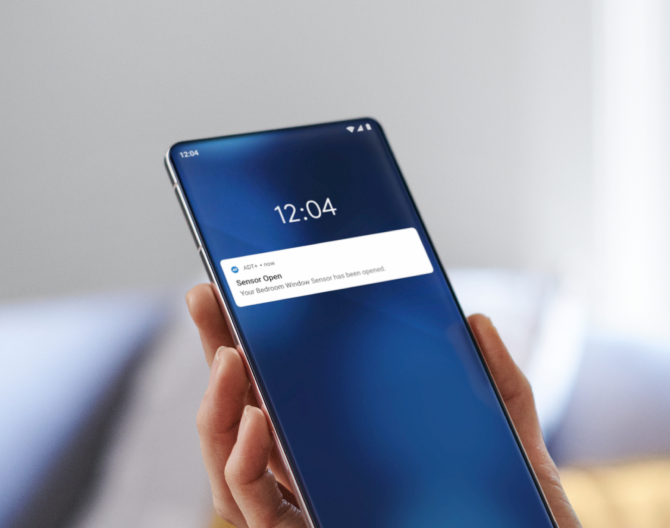 Hand holding an phone that displays ADT mobile alerts