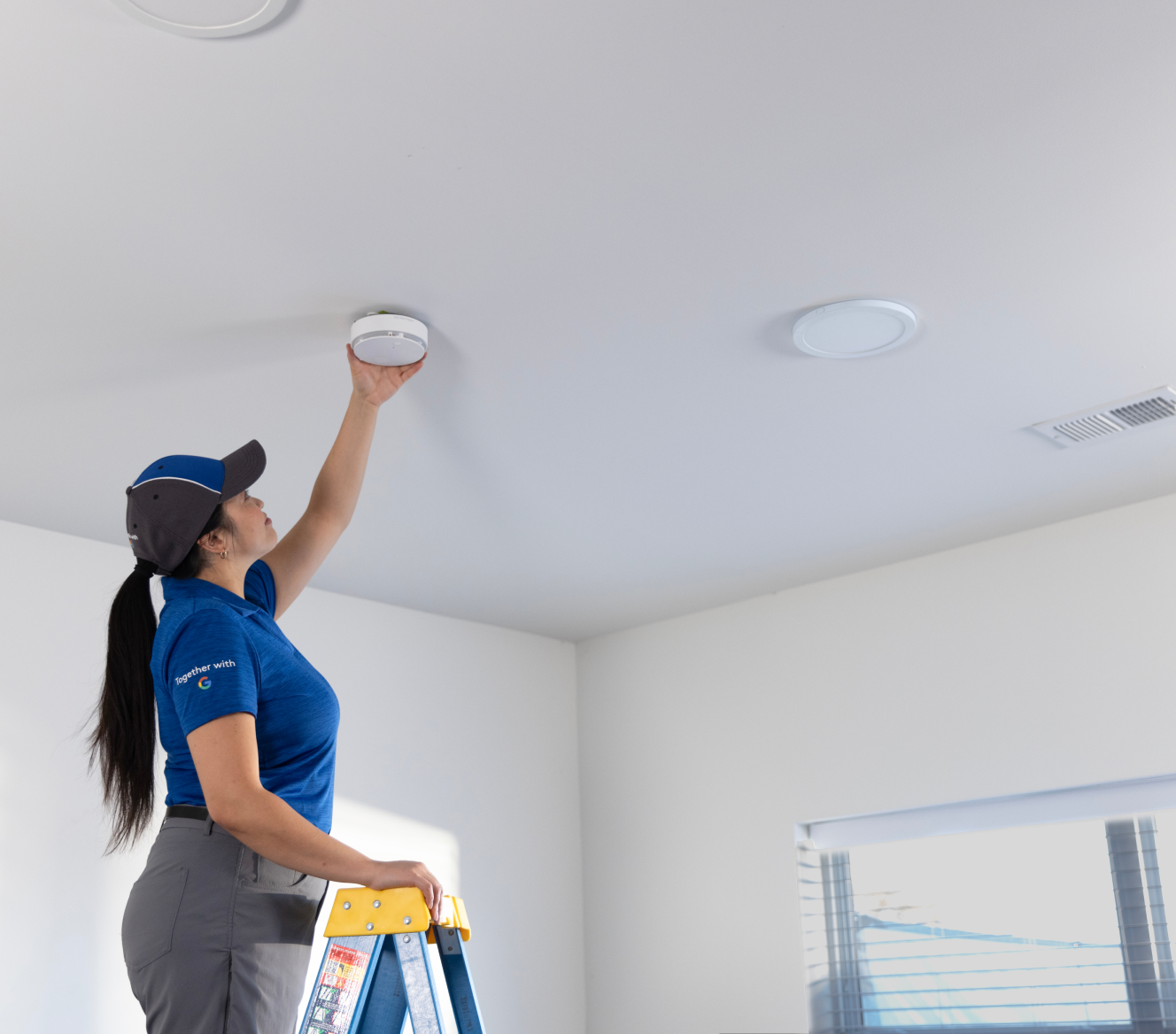 ADT installer installing a heat detector in someone's home