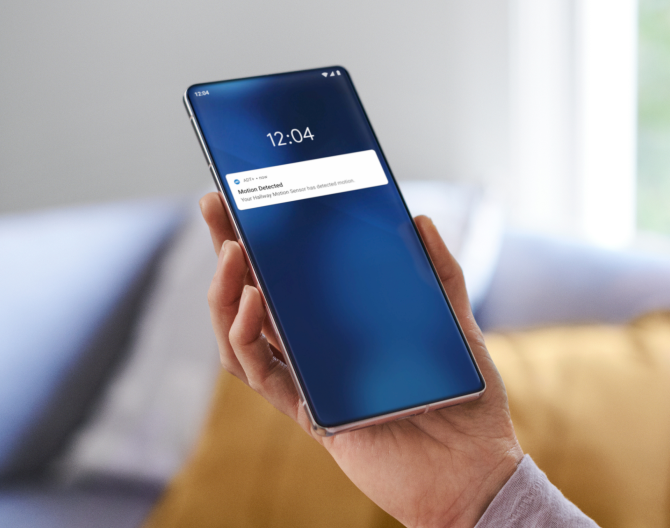Someone holding a phone showing notifications from the ADT app