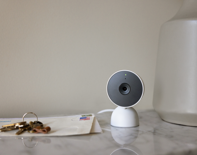 Google Nest Cam (indoor) on a table next to house keys and envelopes